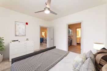 A bedroom with a large bed and a ceiling fan