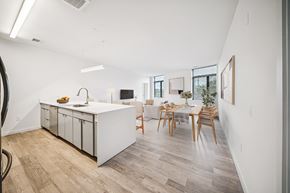 Richmond apartment for rent - A kitchen with a white counter and wooden chairs. at The Locks Tower, Virginia