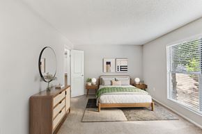 Greenville apartment for rent - A bedroom with a bed, nightstand, and a mirror on the wall at Beacon Ridge Apartments, PRG Real Estate Management, Greenville, 29615