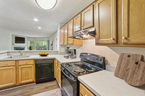 Greenville apartment for rent - A kitchen with wooden cabinets and a black stove top oven at Beacon Ridge Apartments, PRG Real Estate Management, Greenville, 29615