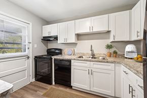 Hampton apartment for rent - A kitchen with white cabinets and a black oven at Rivers Landing Apartments, Hampton 23666