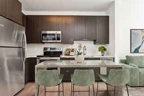 Richmond apartment for rent - a kitchen with a large island with a marble countertop and four green chairs at The Box, Richmond, 23224