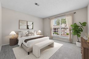 Greenville apartment for rent - Primary bedroom with large windows, plush carpeting and abundant natural light