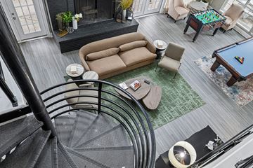 Louisville apartment for rent - A living room with a pool table and a spiral staircase.