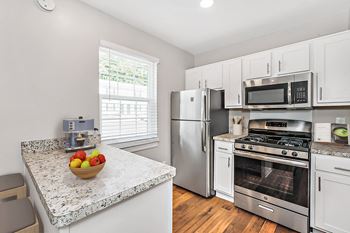 A kitchen with a granite countertop and stainless steel appliances.