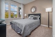 San Antonio apartment for rent - A bedroom with a large bed and a window overlooking a house at Overlook at Stone Oak Park Apartments, San Antonio