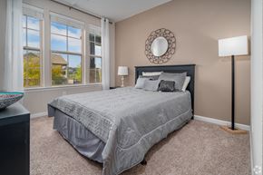San Antonio apartment for rent - A bedroom with a large bed and a window overlooking a house at Overlook at Stone Oak Park Apartments, San Antonio