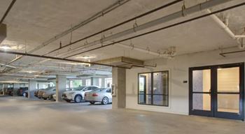 A parking garage with a few cars parked.