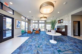 A large room with a blue carpet and a white table in the middle.