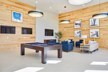A room with a pool table and a couch.