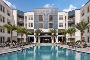 Orlando apartment for rent - A large building with a pool in front of it. at CODA Apartments , Orlando, FL, 32826