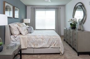 Tampa apartment for rent - A bedroom with a bed, dresser, and mirror.