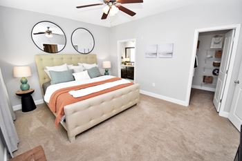 Master bedroom with tufted headboard and ceiling fan