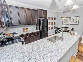 Kitchen island with granite counters and black appliances