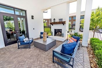 Covered outdoor patio with fireplace and seating area