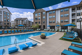 Charlotte apartment for rent - A large swimming pool surrounded by blue lounge chairs and umbrellas at Berewick Pointe Apartments , Charlotte, North Carolina
