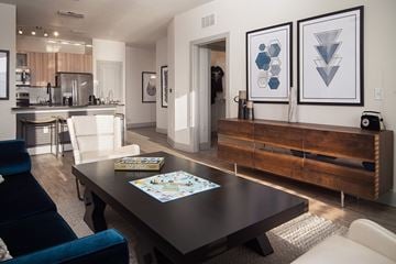 Orlando apartment for rent - A modern living room with a dark wood coffee table and a blue velvet chair.