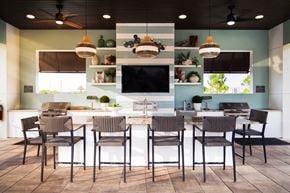 Apopka apartment for rent - Outdoor kitchen with bar seating and flat screen tv at POINTE AT EAST SHORE Apartments, Florida, 32703