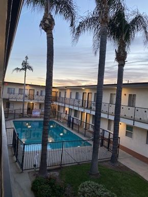 Mission Hills apartment for rent - A pool surrounded by palm trees and apartment buildings.