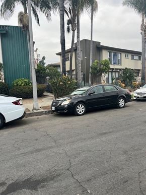 Los Angeles apartment for rent - A black car is parked on the side of a street.