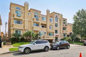 Los Angeles apartment for rent - A white SUV is parked in front of a black sedan in a parking lot.