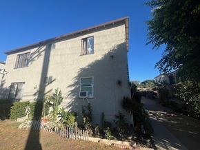 Van Nuys apartment for rent - A house with a brown roof and a white wall with a window and a door.