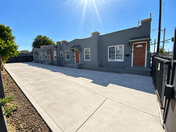 Los Angeles apartment for rent - A sunny day in front of a grey building with a brown door.