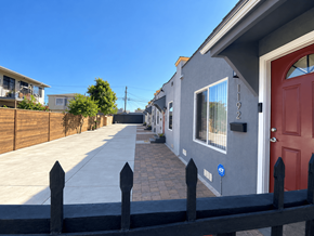 Los Angeles apartment for rent - A row of houses with a red door and a blue sign on the wall.