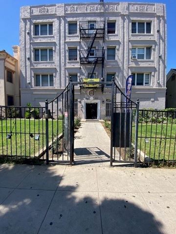 Los Angeles apartment for rent - A tall building with a black gate in front.