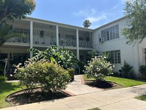 Los Angeles apartment for rent - A white building with a balcony and a tree in front.