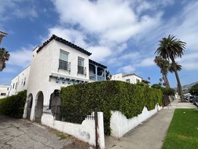 Los Angeles apartment for rent - A white house with a black gate and a green hedge.