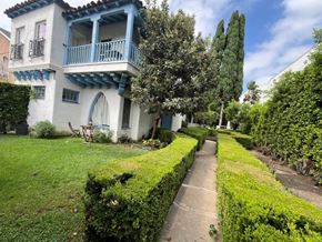 Los Angeles apartment for rent - A white and blue house with a balcony and a hedge in the front yard.