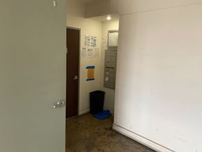 Los Angeles apartment for rent - A room with a door, a trash bin, and some papers on the wall.