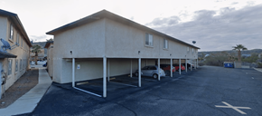 Bullhead City apartment for rent - A parking lot with a building and cars parked.