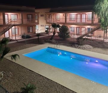Bullhead City apartment for rent - A swimming pool in front of a building at night.
