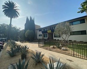 Los Angeles apartment for rent - A sunny day at a residential area with a house, trees, and a palm tree.