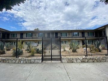 Los Angeles apartment for rent - A black iron fence surrounds a building.
