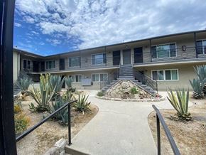 Los Angeles apartment for rent - A concrete walkway leads to a building with a stone staircase.