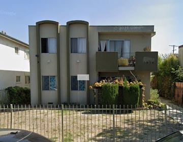 Los Angeles apartment for rent - A three-story building with a balcony and a fence in front.