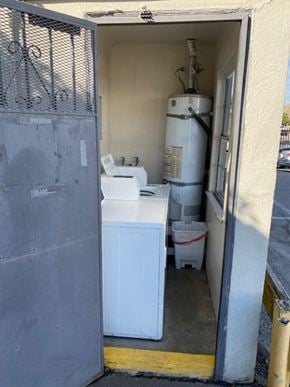 Los Angeles apartment for rent - A white washing machine is in a doorway with a grey wall.