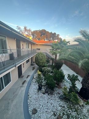 Inglewood apartment for rent - A balcony overlooks a landscaped garden with a gravel path and a variety of plants.