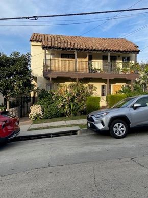 Los Angeles apartment for rent - A silver car is parked on the side of a street in front of a house with a red car behind it.