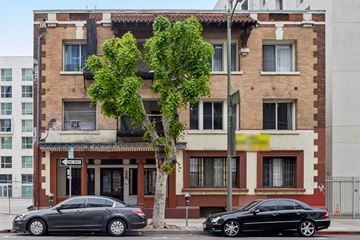 Los Angeles apartment for rent - Two cars parked in front of a building with a tree in between.