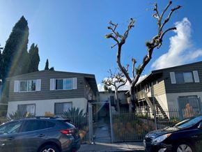 Los Angeles apartment for rent - A grey car is parked in front of a house with a tree in front of the house.