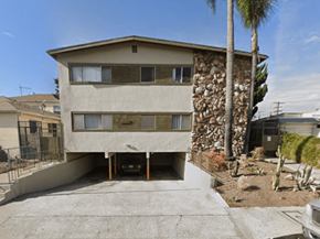 Los Angeles apartment for rent - A house with a stone wall and a palm tree in front.