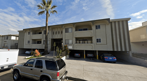 Los Angeles apartment for rent - A silver SUV is parked in front of a building with a palm tree in the background.