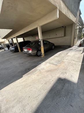 Los Angeles apartment for rent - A concrete parking garage with cars parked under a roof.