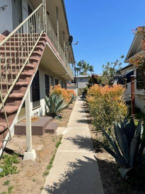 Los Angeles apartment for rent - A concrete pathway leads to a staircase outside a building.