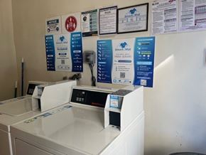 Los Angeles apartment for rent - A wall of signs are on a wall above a washing machine.