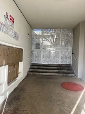Los Angeles apartment for rent - A hallway with a red mat on the floor and a metal gate in the background.